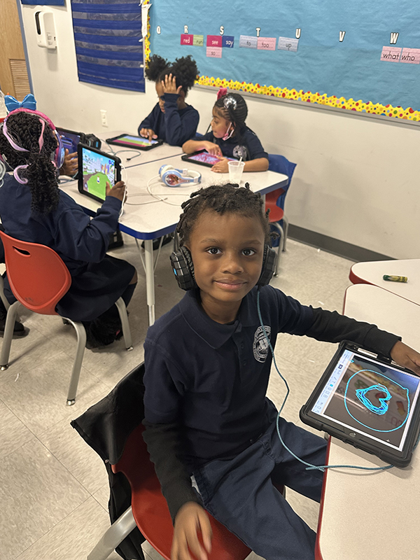Boy wearing headphones with a computer tablet